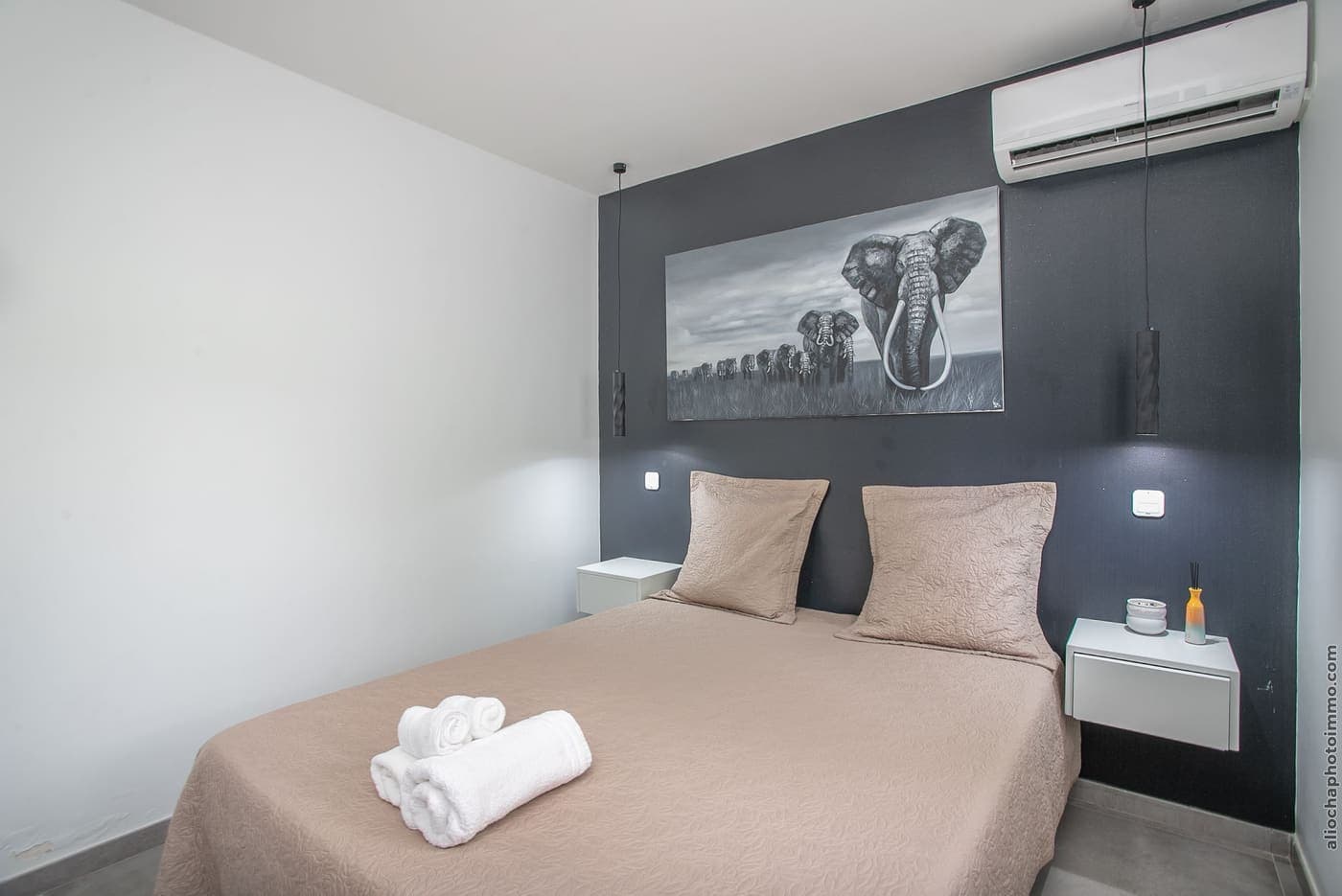 La chambre 2 : lit double sous un tableau, mur d'accent et fenêtre ouverte