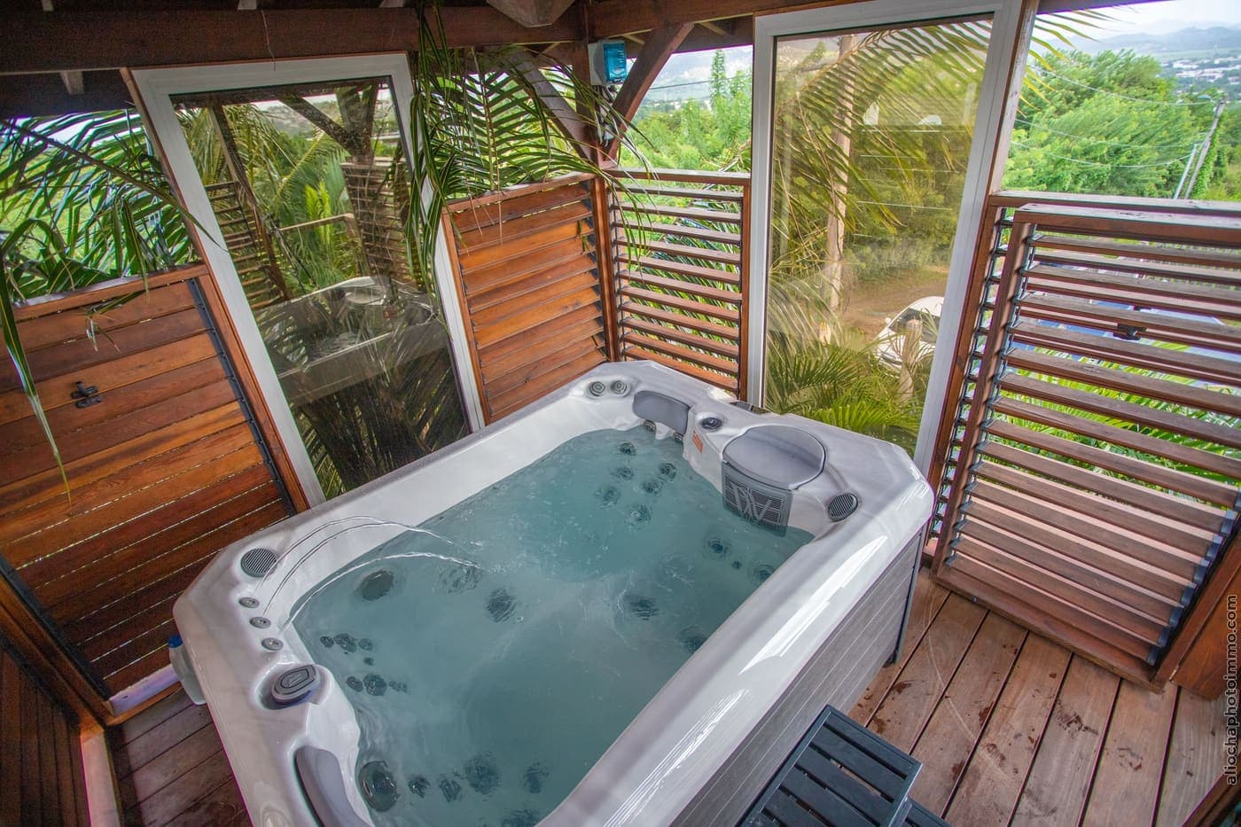 Le jacuzzi dans sa tour en bois à claire-voie, ouvert sur la plaine