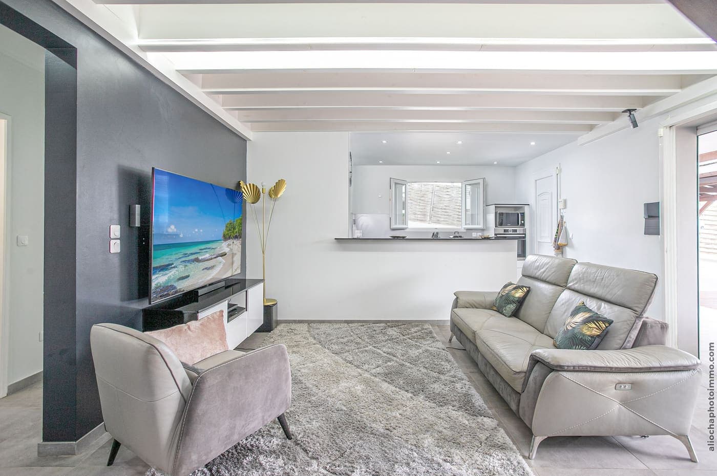 Le salon ouvert de la villa, canapés et grand écran, sous la mezzanine