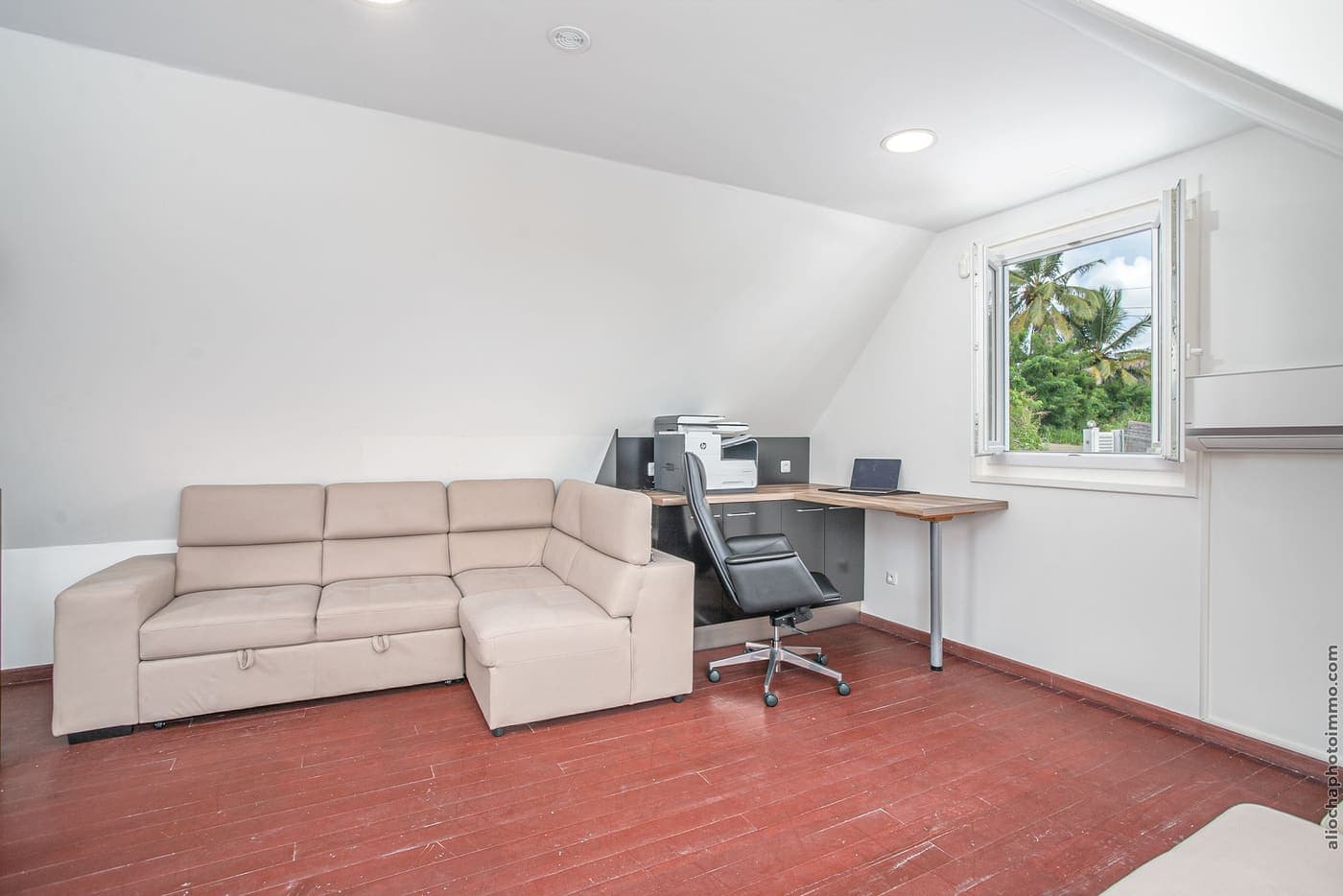 The SkyRoom's desk corner: table, armchair and sofa under the roof